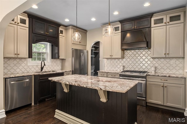 582 S Berry Rd, Webster Groves, MO 63122 - kitchen with stainless steel appliances, a sink, custom exhaust hood, arched walkways, and recessed lighting