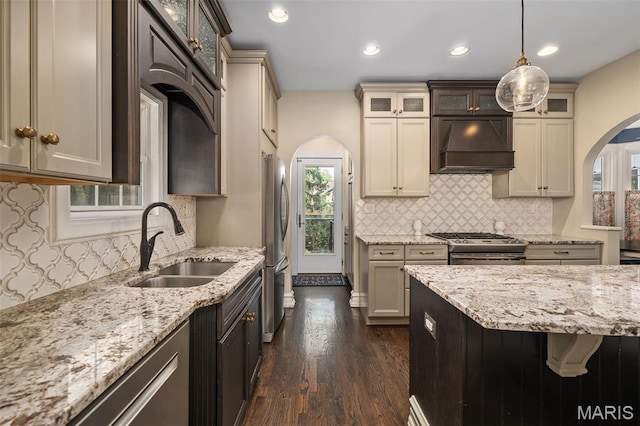 582 S Berry Rd, Webster Groves, MO 63122 - kitchen with a sink, arched walkways, ventilation hood, light stone counters, and dark wood-style flooring