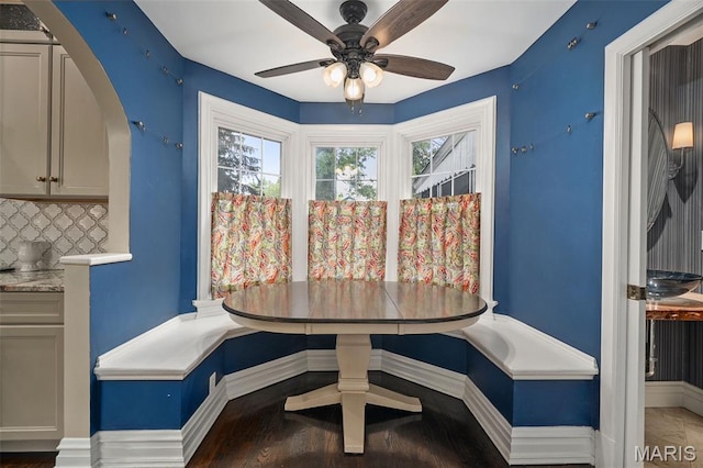 582 S Berry Rd, Webster Groves, MO 63122 - dining space with breakfast area, a ceiling fan, baseboards, arched walkways, and wood finished floors