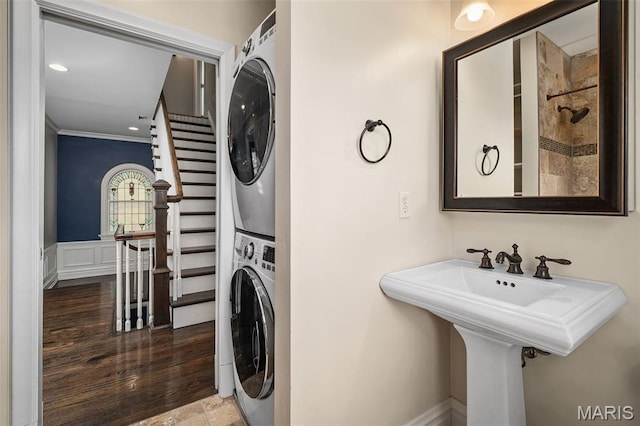 582 S Berry Rd, Webster Groves, MO 63122 - laundry room featuring stacked washer and clothes dryer, ornamental molding, and wood finished floors