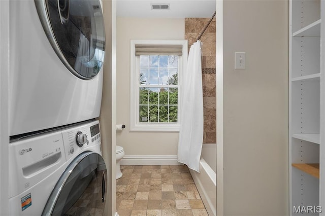 582 S Berry Rd, Webster Groves, MO 63122 - washroom featuring stacked washer and clothes dryer, baseboards, and stone finish floors