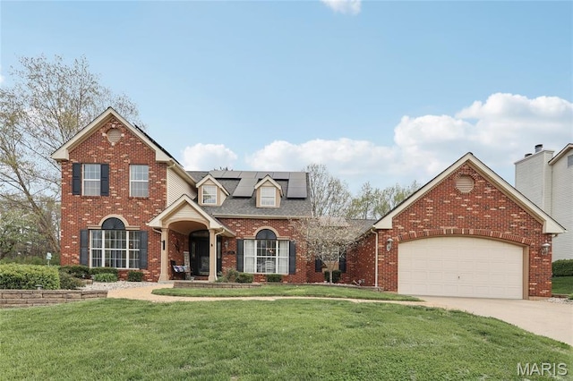 1001 Hawthorne Pl, Ofallon, IL 62269 - traditional-style house with a front lawn, roof mounted solar panels, brick siding, an attached garage, and concrete driveway