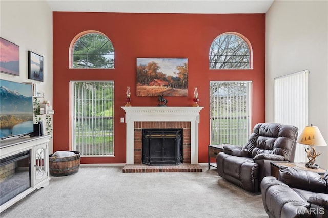 1001 Hawthorne Pl, Ofallon, IL 62269 - living room featuring a fireplace, carpet floors, a towering ceiling, and healthy amount of natural light