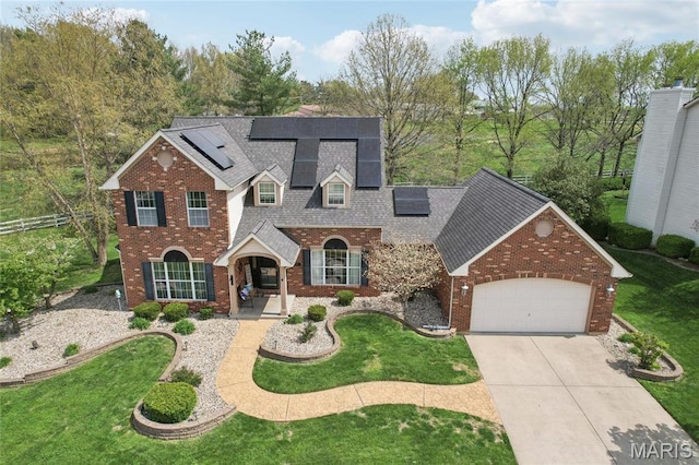 1001 Hawthorne Pl, Ofallon, IL 62269 - traditional home featuring an attached garage, concrete driveway, solar panels, brick siding, and a shingled roof