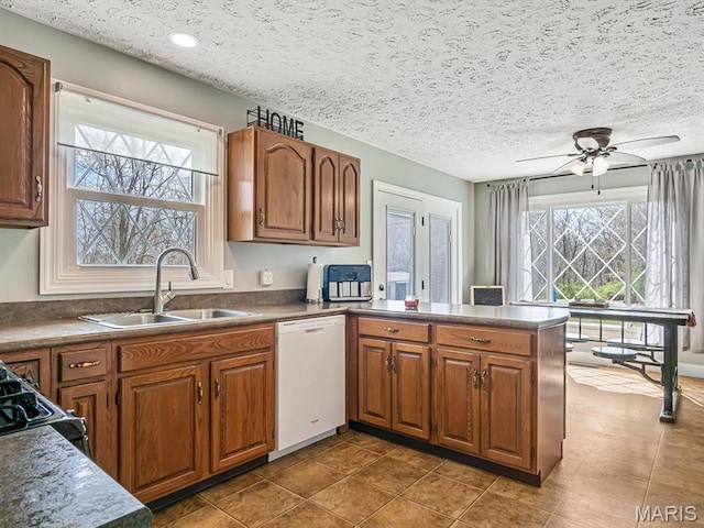7506 D Rd, Waterloo, IL 62298 - kitchen with dishwasher, a sink, a peninsula, a ceiling fan, and brown cabinets