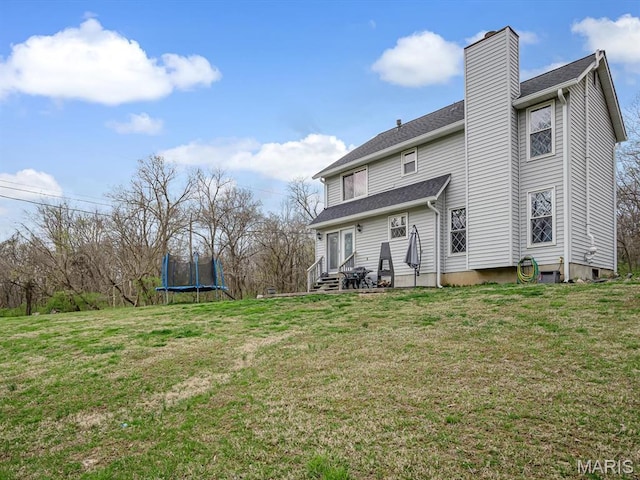 7506 D Rd, Waterloo, IL 62298 - rear view of house featuring a trampoline, a chimney, a yard, and entry steps