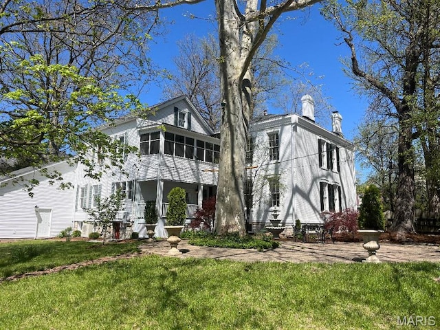 445 E 12th St, Alton, IL 62002 - view of front facade featuring a sunroom, a front lawn, and a chimney