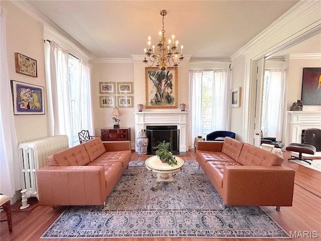 445 E 12th St, Alton, IL 62002 - living room featuring a fireplace, radiator heating unit, wood finished floors, a chandelier, and ornamental molding