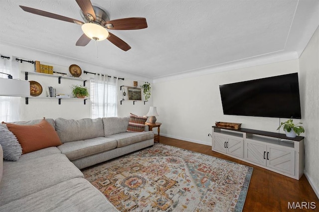 living area featuring dark wood-style floors, a ceiling fan, and baseboards