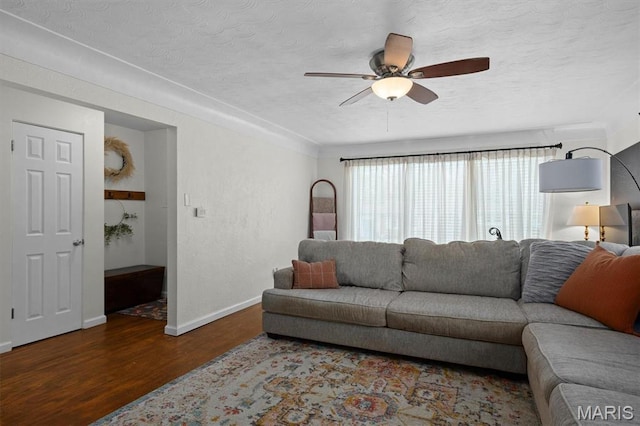 living room with wood finished floors, baseboards, ceiling fan, and a textured ceiling