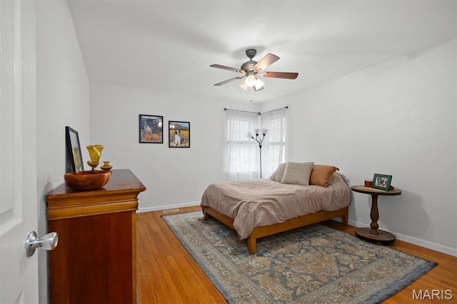 bedroom featuring wood finished floors, baseboards, and ceiling fan
