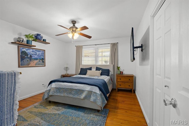 bedroom with wood finished floors, baseboards, and ceiling fan
