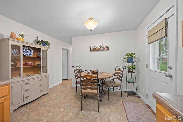 dining space featuring stone finish floors and baseboards