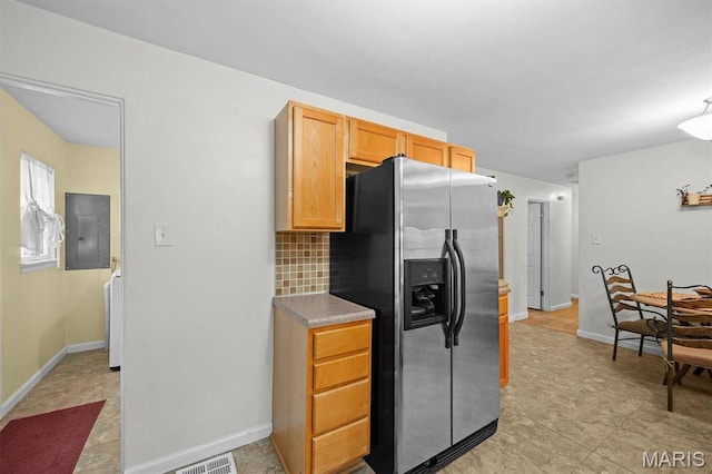 kitchen with stainless steel refrigerator with ice dispenser, electric panel, backsplash, baseboards, and washer / clothes dryer