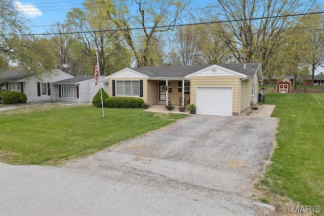 single story home with an attached garage, driveway, a storage unit, a front yard, and an outdoor structure