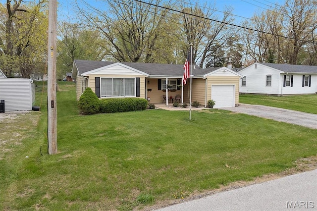 view of front of house featuring an attached garage, dirt driveway, covered porch, and a front lawn