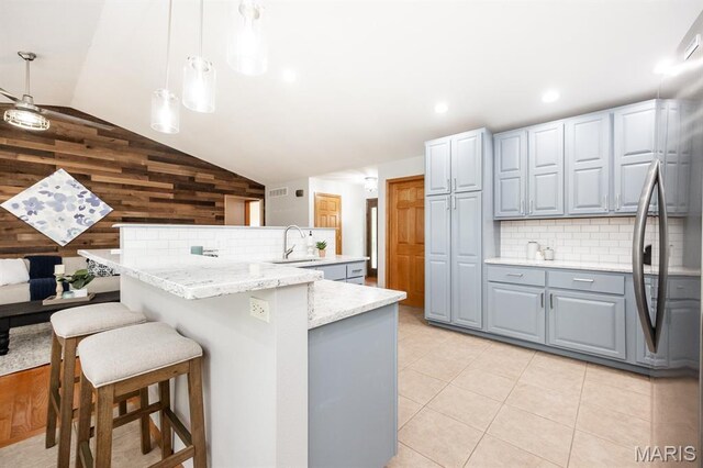 92 Rinderer Rd, Trenton, IL 62293 - kitchen with gray cabinetry, vaulted ceiling, wood walls, tasteful backsplash, and a sink