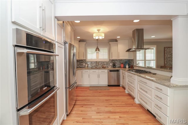 616 W Capri Dr, Bonne Terre, MO 63628 - kitchen featuring stainless steel appliances, island exhaust hood, ornamental molding, a sink, and backsplash