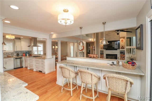 616 W Capri Dr, Bonne Terre, MO 63628 - kitchen with appliances with stainless steel finishes, a peninsula, ventilation hood, open floor plan, and light stone countertops