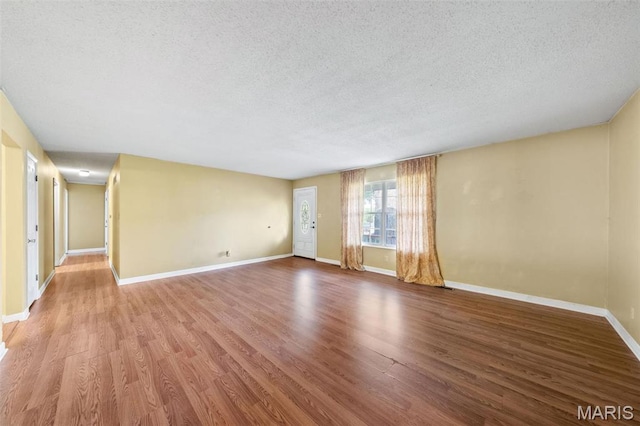 4044 Locke Ave, Bridgeton, MO 63044 - unfurnished living room featuring a textured ceiling, wood finished floors, and baseboards