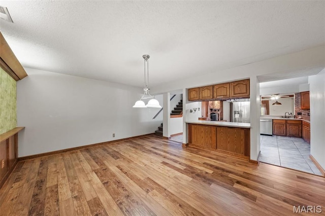 4044 Locke Ave, Bridgeton, MO 63044 - kitchen featuring appliances with stainless steel finishes, brown cabinets, light wood-style flooring, and a sink