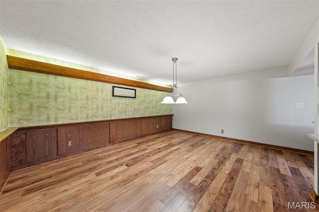 4044 Locke Ave, Bridgeton, MO 63044 - unfurnished dining area featuring wood finished floors, a textured ceiling, and baseboards