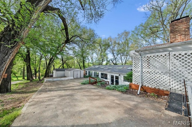 4044 Locke Ave, Bridgeton, MO 63044 - view of property exterior featuring a chimney, a storage shed, an outbuilding, and driveway