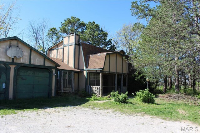 view of front of property with a garage, a shingled roof, and a sunroom