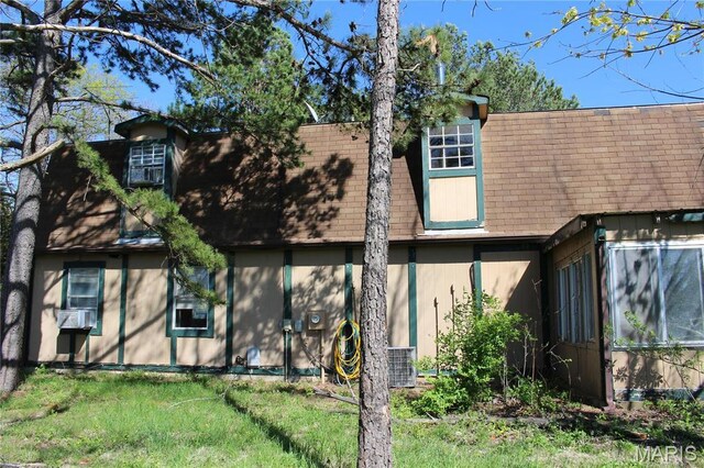 back of property featuring a shingled roof, central AC unit, and a sunroom