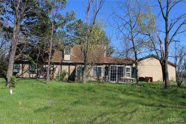 rear view of house featuring a lawn