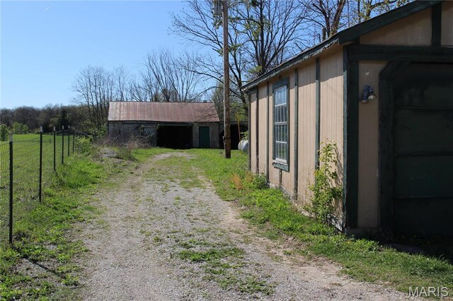 view of side of home with fence and driveway