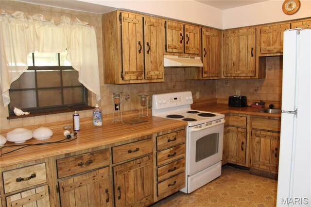kitchen featuring white appliances, under cabinet range hood, brown cabinets, and backsplash