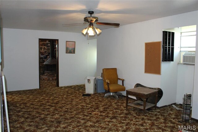 living area with ceiling fan, carpet floors, and a wood stove
