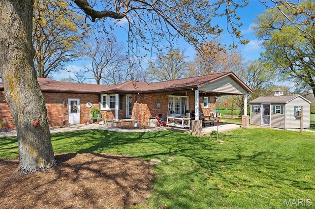 21510 Keyesport Rd, Keyesport, IL 62253 - back of property featuring brick siding, an outbuilding, a lawn, and a patio