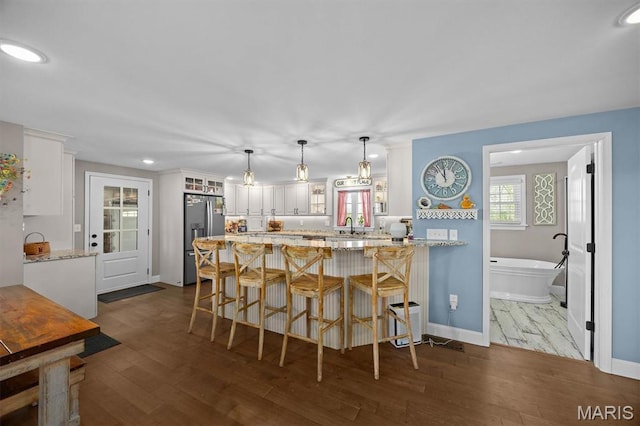 21510 Keyesport Rd, Keyesport, IL 62253 - kitchen with stainless steel fridge, white cabinets, a sink, glass insert cabinets, and a peninsula
