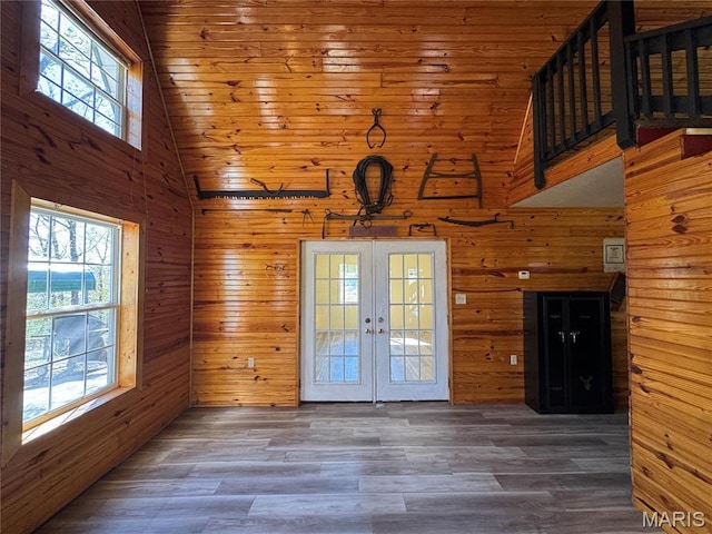 entryway featuring french doors, high vaulted ceiling, wooden walls, wood finished floors, and wooden ceiling