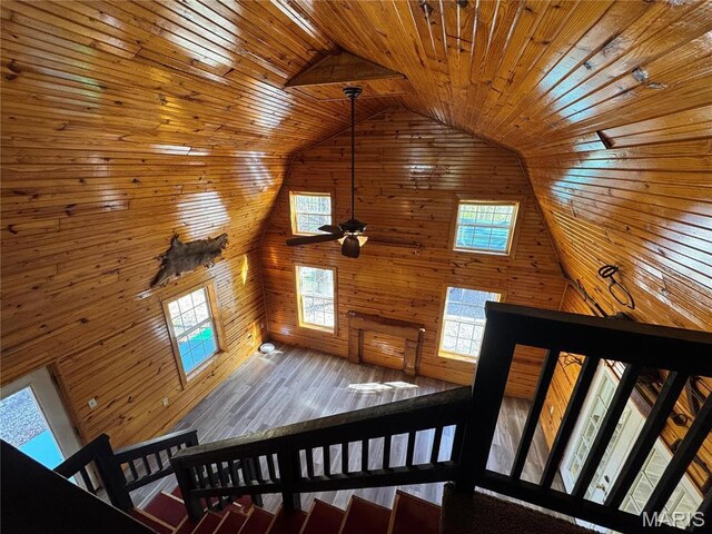 living room featuring wood walls, healthy amount of natural light, wooden ceiling, wood finished floors, and high vaulted ceiling