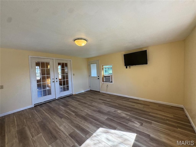 spare room with french doors, baseboards, dark wood-style flooring, and a textured ceiling