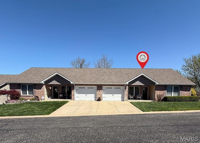 ranch-style house with brick siding, an attached garage, a front yard, and concrete driveway