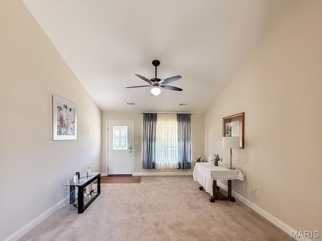 entrance foyer with carpet floors, ceiling fan, baseboards, and vaulted ceiling