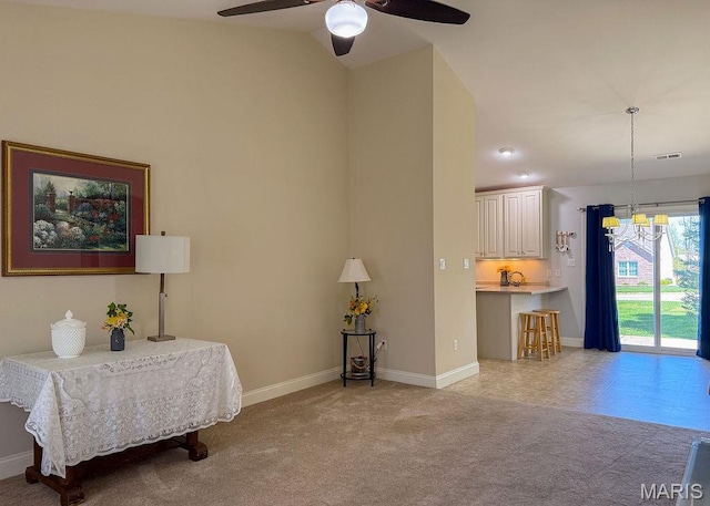 living area with a ceiling fan, baseboards, a chandelier, lofted ceiling, and light colored carpet