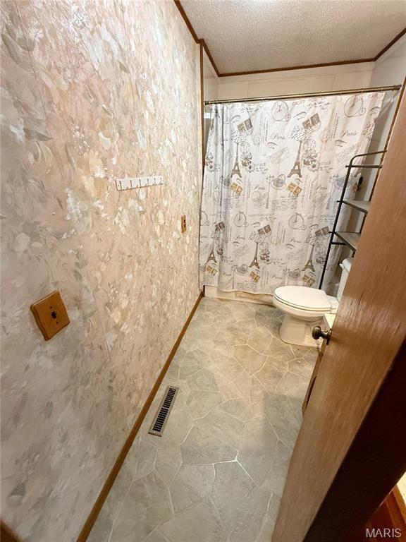 520 Keeton Rd, Rolla, MO 65401 - full bathroom featuring toilet, crown molding, curtained shower, baseboards, and a textured ceiling