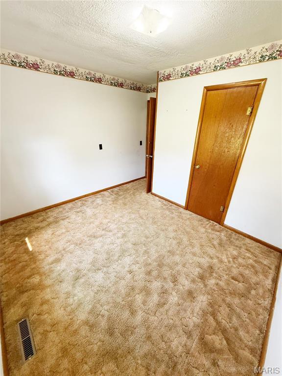 520 Keeton Rd, Rolla, MO 65401 - spare room with a textured ceiling, baseboards, and carpet flooring