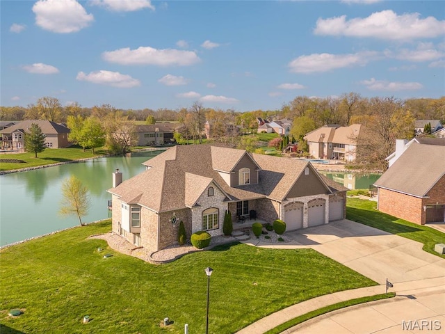2017 Richview Dr, Saint Jacob, IL 62281 - view of front facade featuring concrete driveway, a water view, a garage, a residential view, and a front yard