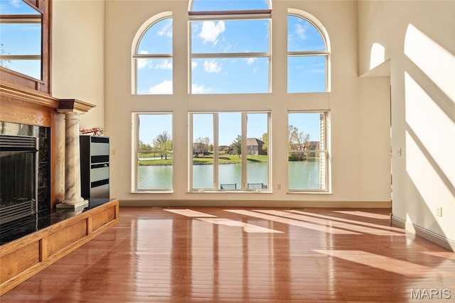 2017 Richview Dr, Saint Jacob, IL 62281 - unfurnished living room with wood finished floors, a fireplace, healthy amount of natural light, a water view, and a high ceiling