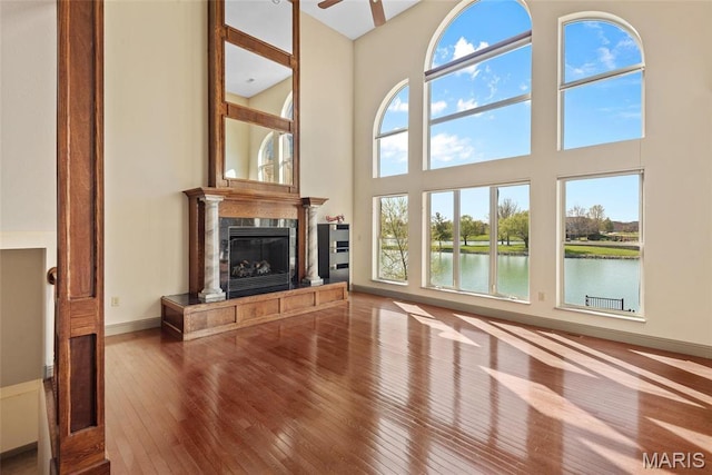 2017 Richview Dr, Saint Jacob, IL 62281 - unfurnished living room with wood-type flooring, a high ceiling, a high end fireplace, a water view, and ceiling fan