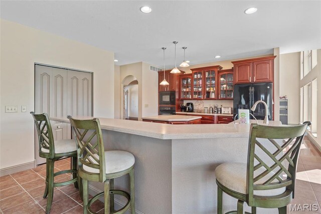 2017 Richview Dr, Saint Jacob, IL 62281 - kitchen with black appliances, arched walkways, a kitchen island, a kitchen breakfast bar, and recessed lighting