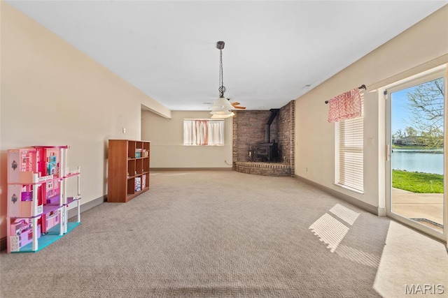 2017 Richview Dr, Saint Jacob, IL 62281 - unfurnished living room with a wood stove, carpet flooring, baseboards, and a water view