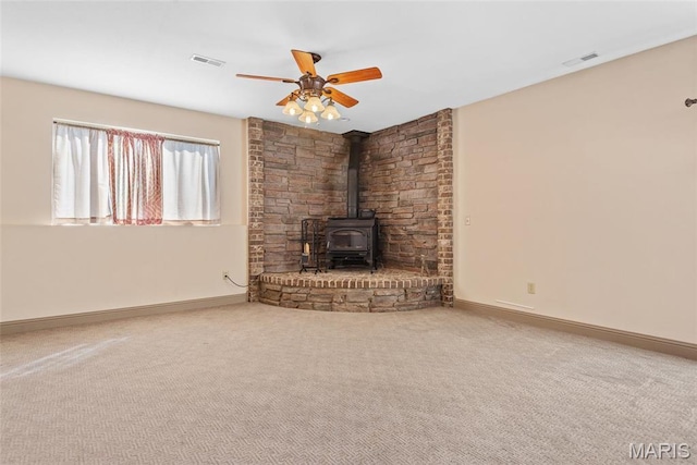 2017 Richview Dr, Saint Jacob, IL 62281 - unfurnished living room featuring ceiling fan, a wood stove, carpet floors, and baseboards