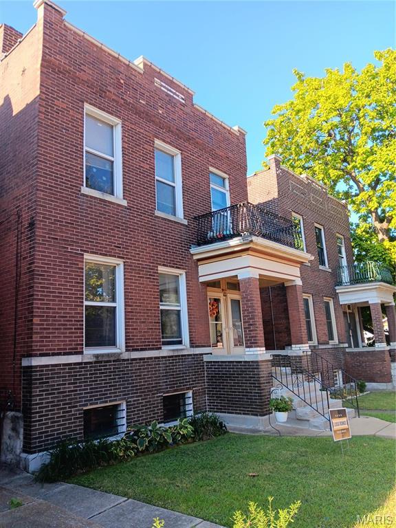 3464 Montana St, Saint Louis, MO 63118 - view of front facade with brick siding, a balcony, and a front lawn